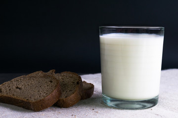 Background food ingredients on the tablecloth. Homemade bread and milk.