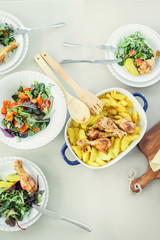 Roasted chicken with potato, healthy salads on table. Top view. Flat lay