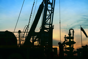 Pumping unit in the work, under the background of the setting sun