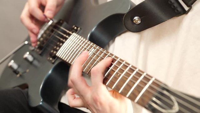 Male hands with electric guitar. Close up, part body adult person is holding instrument and playing. Hobby, music concept. 4K ProRes HQ codec