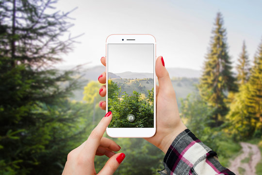 Girl photographing landscape with modern smartphone