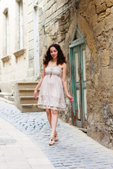 Fototapeta na wymiar Young girl strolling through narrow streets