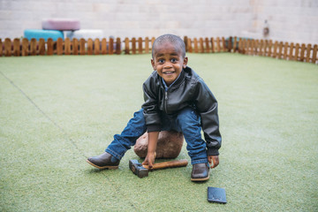 Child breaks telephone with hammer