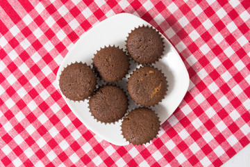 Mini cocoa muffins on white plate