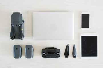 Obraz premium (travel concept) Photographic equipment, Laptop, tablet, smartphone, drone, controller and batteries on a white desk.
