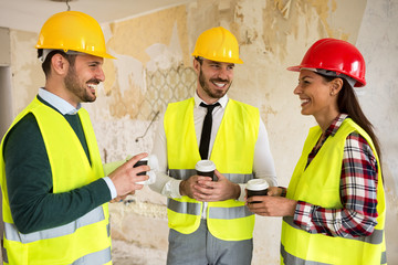 Group of architects talking on coffee break at construction site