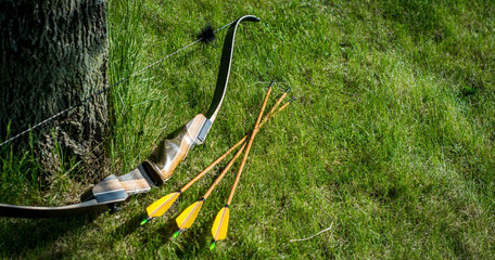 Traditional archery re-curve bow in the grass with arrows