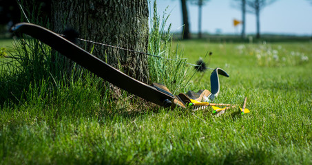 Traditional archery re-curve bow in the grass with arrows