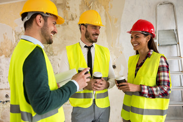 Group of architects talking on coffee break at construction site