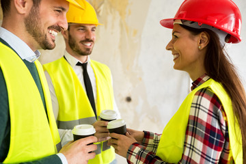Group of architects talking on coffee break at construction site