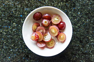 Fresh grapes cut into small pieces inside a bowl