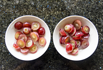 Fresh grapes cut into small pieces inside two bowls