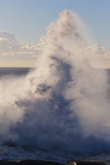 Aftermath of wave crashing into rocks.