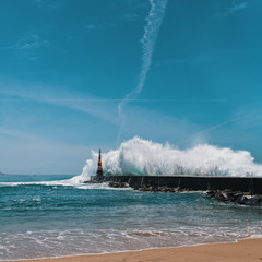 Fototapeta na wymiar Powerful surf on the ocean coast, near the lighthouse. Porto, Portugal.