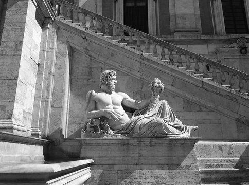 Ancient Roman Statue of the Tiber River God (Tiberinus) holding a cornucopia in the Piazza del Campidoglio, designed by Michelangelo, in Rome, Italy. Black and white image.