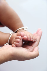 Mother holds baby feet in hands.