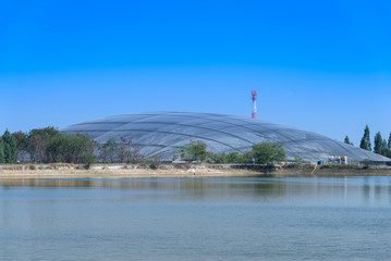 plastic cover of storage facility and production of bio gas from sugar cane oil refinery plant with surface of pond in foreground