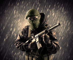 Armed terrorist man with mask on rainy background