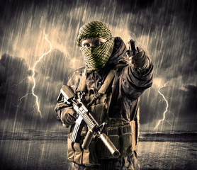 Dangerous armed terrorist with mask and gun in a thunderstorm with lightning