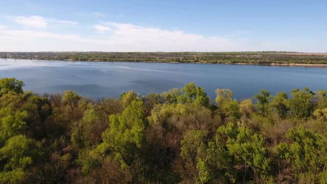 Impressive aerial  view on the sparkling blue waters of the Dnipro river and its picturesque riverbank in a sunny day in spring. The skyscape and horizon look  great and gorgeous.