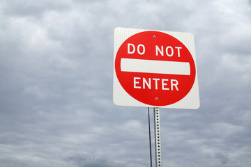 do not enter sign against cloudy sky
