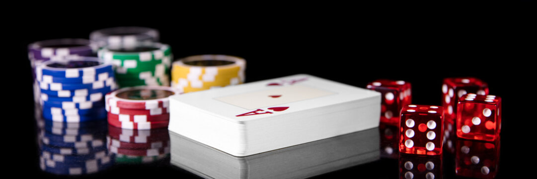 Spielkarten, W&uuml;rfel und Jetons vor Schwarz, Konzept Spielwetten und Gl&uuml;cksspiel