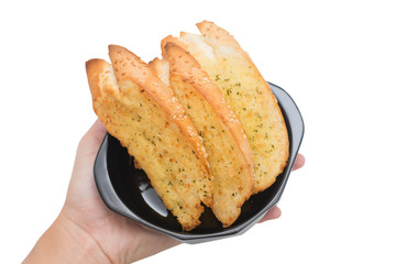 Garlic bread in black bowl on hand.
