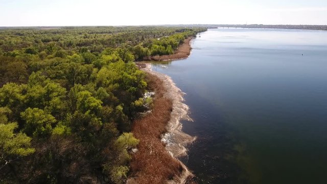 Astonishing aerial shot of the Dnipro river basin with sparkling waters, curvy  river bank, wild greenary, forest boscages, small inflows,  nice skyscape, in Ukraine in  a sunny day in spring