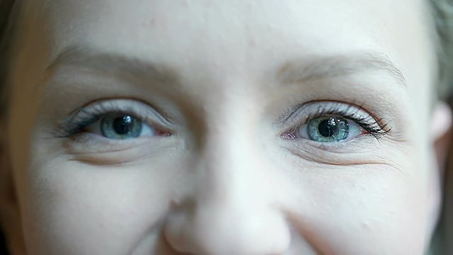 Girl looks happy while raising eyebrows and doing squint to the camera
