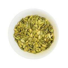 Pumpkin seeds in a bowl isolated on white