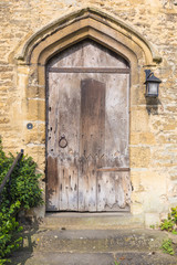 Fototapeta na wymiar old european wooden door on thick stone wall