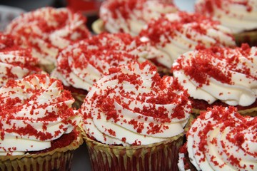Group of homemade Red Velvet  cupcakes with cream cheese on top.