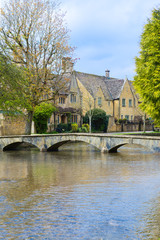 view of houses along walking bridge over the water in Bourton On The Water, England