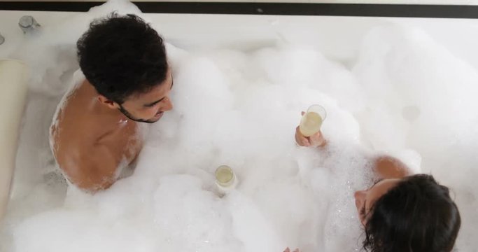 Young Couple In Bath Together Drink Champagne Talking Top Angle View, Man And Woman Lover Enjoy Spa At Home Slow Motion 60