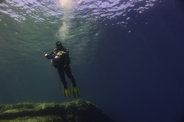 Obraz na płótnie Canvas Underwater Photographer Hovering Over a Reef