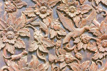 Carved bird and flowers on the wood background, horizontal photo