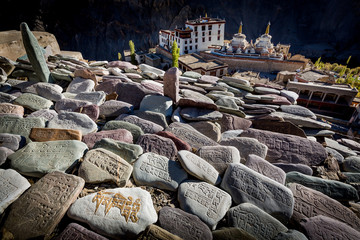 Prayer stones with carved mantras with Tibetan script above the Buddhist monastery of Lamayuru in...