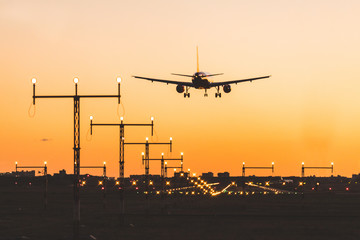Airplane landing at sunset, silhouette