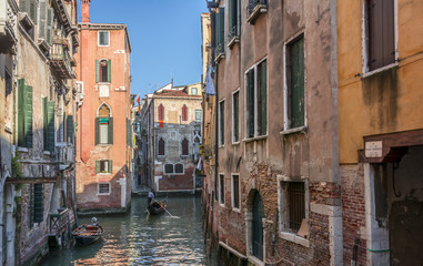 Obraz na płótnie Canvas Venetian gondolier on small canal in Venice, Italy.