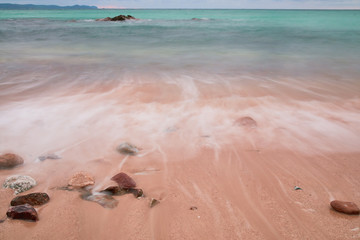 Soft wave of blue ocean on sandy beach. Background.
