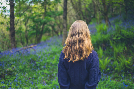 Woman standing in meadow of bluebells