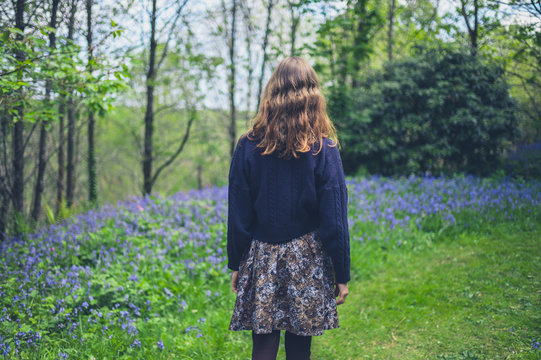 Woman walking in forest with bluebells