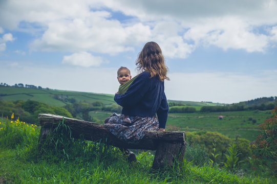 Woman with baby on bench in nature