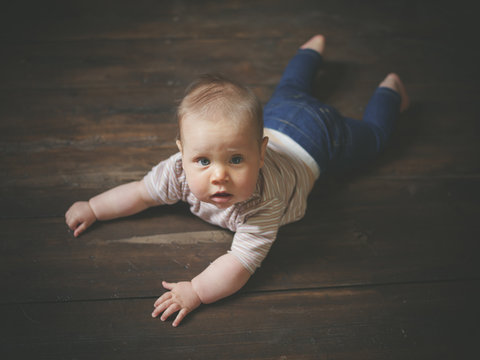 Little baby on wooden floor