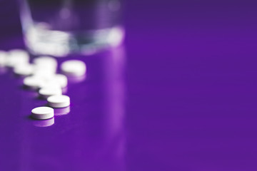 White rounded pills over a violet board with optical bokeh effect