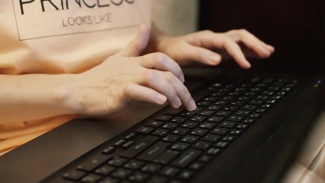 Female hands typing text on the keyboard close-up