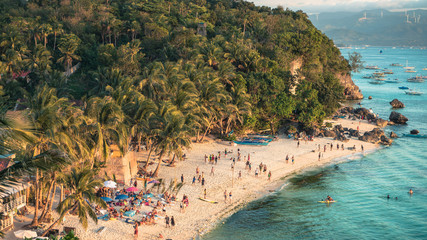 Beautiful Diniwid Beach full of people on Boracay, Philippines, during sunset