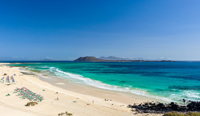 Fototapeta na wymiar XXL panorama view of the islands of Lobos and Lanzarote seen from Corralejo Beach (Grandes Playas de Corralejo) on Fuerteventura, Canary Islands, Spain, Europe. Beautiful turquoise water & white sand.