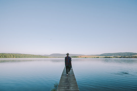 Woman walking on pier by the lake