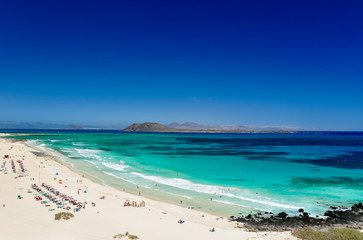 Panorama view of the islands of Lobos and Lanzarote seen from Corralejo Beach (Grandes Playas de Corralejo) on Fuerteventura, Canary Islands, Spain, Europe. Beautiful turquoise water & white sand.
